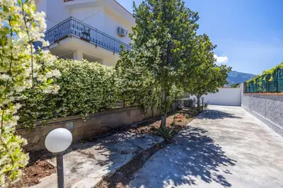 a building with trees in front of a sidewalk at Casa Cloe Mondello in Palermo