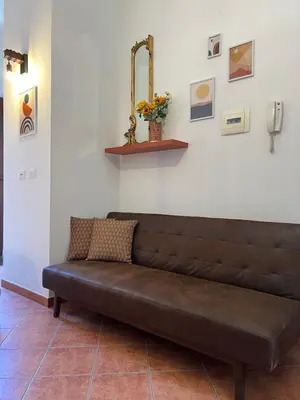 a brown leather couch sitting in a room at Casamori 3- nel cuore del mercato Ballarò in Palermo
