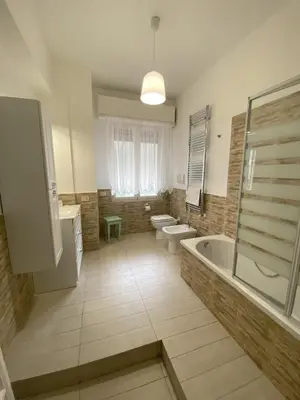 a bathroom with two toilets and a tub and a sink at La Casa di Baloo in Palermo