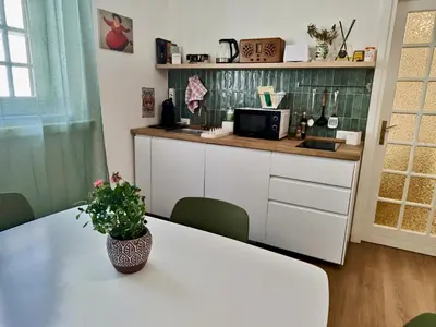 a kitchen and living room with a white table and chairs at Maskan Palermo centro in Palermo