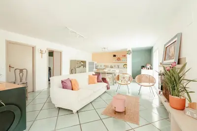 a living room with a white couch and a kitchen at Nuccia's home vacanze in natura in Ficarazzi