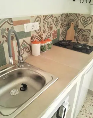 a kitchen counter with a sink in a kitchen at Villetta Casaurro in Bagheria