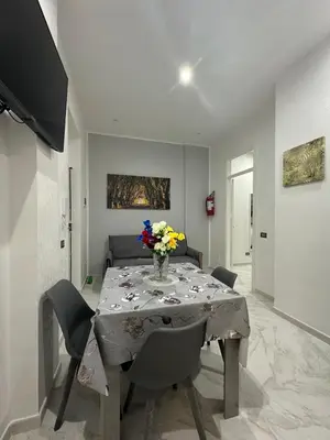 a dining room table with a vase of flowers on it at Agadir Apartment in Palermo