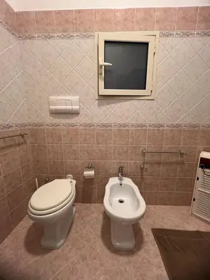 a bathroom with a toilet and a tv on the wall at Al Tribunale Guest House in Palermo
