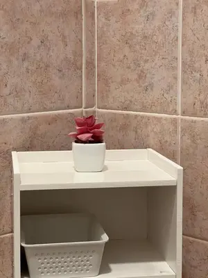a white shelf with a flower in a bowl on it at Al Tribunale Guest House in Palermo