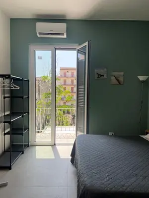 a bedroom with a bed and a door to a balcony at Al Tribunale Guest House in Palermo
