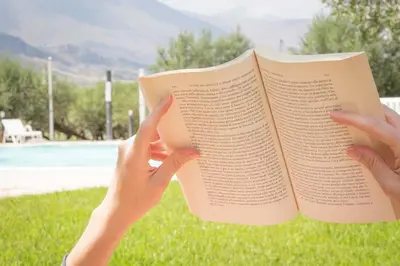 a person holding a book in their hands at Casale La Macina - Hotel, Scopello in Scopello