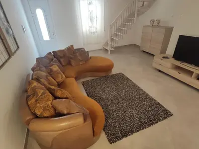 a living room with a brown couch and a television at Central modern vacation home in Lascari - Casa Vacanze Luna in Lascari