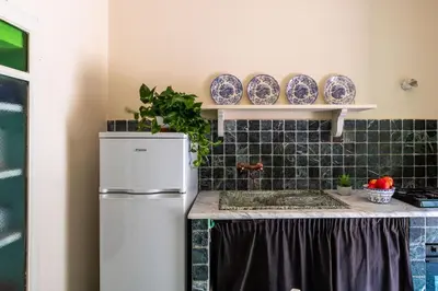 a kitchen with a refrigerator and plates on the wall at iFlat Suite del Barone with Terrace in Palermo