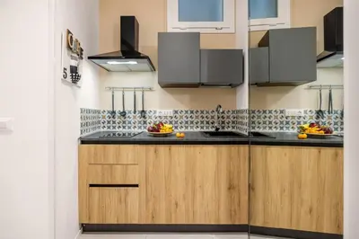 a kitchen with wooden cabinets and black counter tops at Vittorio Maison - centro storico in Palermo
