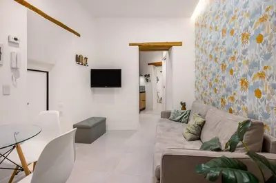 a living room with a couch and a tv on a wall at Vittorio Maison - centro storico in Palermo