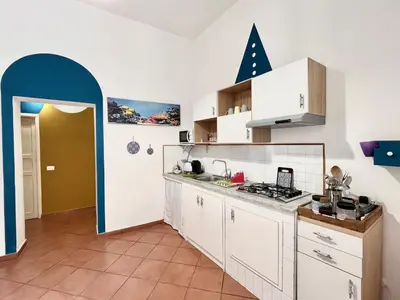 a kitchen with white cabinets and a blue doorway at La Loggia del Capo in Palermo
