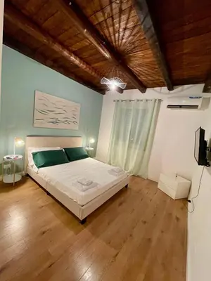 a bedroom with a large bed and a wooden floor at Vicolo Morici in Palermo