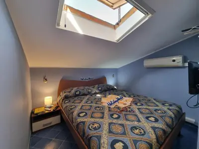 a bedroom with a large bed with a skylight at Respiro di Mare by Holiday World in Buonfornello