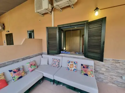 a white couch with pillows sitting on a balcony at Respiro di Mare by Holiday World in Buonfornello