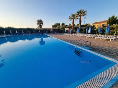 a large swimming pool with chairs and umbrellas at Respiro di Mare by Holiday World in Buonfornello