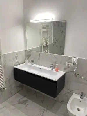 a bathroom with a sink and a mirror and a toilet at Palermo Flowers Suites in Palermo