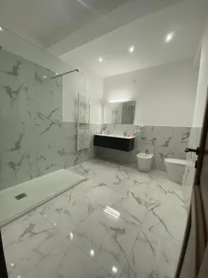 a white bathroom with a tub and a toilet and a sink at Palermo Flowers Suites in Palermo