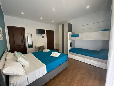 a bedroom with two bunk beds with blue sheets at Palermo Flowers Suites in Palermo