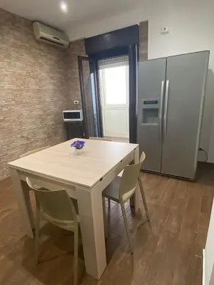 a kitchen with a table with chairs and a refrigerator at Palermo Flowers Suites in Palermo