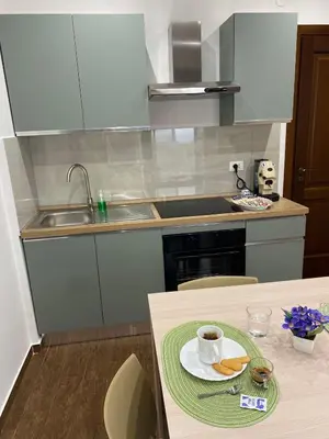 a kitchen with a sink and a table with a cup of coffee at Palermo Flowers Suites in Palermo