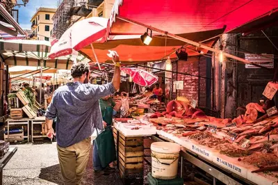 a man holding an umbrella at a fish market at Volturno 50 in Palermo