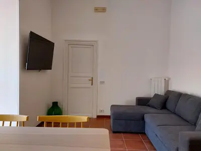 a living room with a blue couch and a tv at Volturno 50 in Palermo