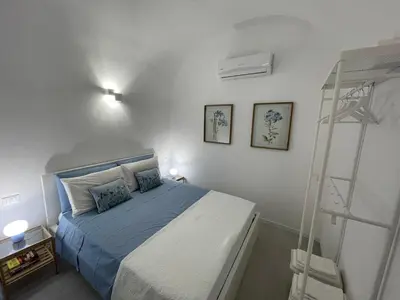 a bedroom with a bed with blue sheets and a ladder at Anfrasipe apartment in Terrasini