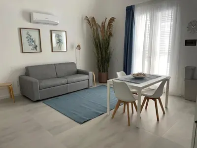a living room with a couch and a table and chairs at Anfrasipe apartment in Terrasini
