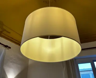 a large yellow light hanging from a ceiling at Casa ducrot in Palermo