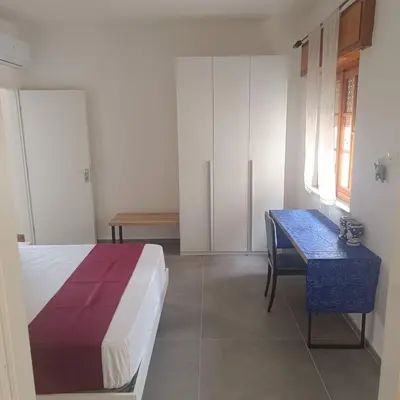 a bedroom with a bed and a desk in it at Cà Porto-Rooms with Balcony&Terrace in Santa Flavia