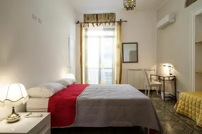 a bedroom with a bed with a red blanket and a window at B&B del Massimo in Palermo