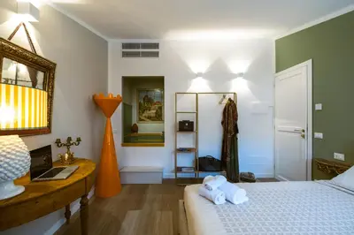 a bedroom with a bed and a desk and a mirror at Royal House Palermo in Palermo