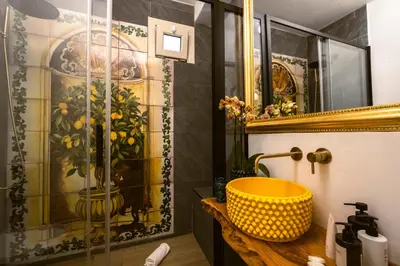 a bathroom with a shower with a yellow sink at Royal House Palermo in Palermo