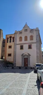 a large stone building with a door in a parking lot at Casa del Vecchio Borgo in Caccamo