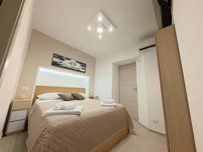 a bedroom with a bed with two towels on it at A Little Modern House in Palermo