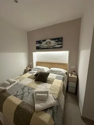 a bedroom with a bed with towels on it at A Little Modern House in Palermo
