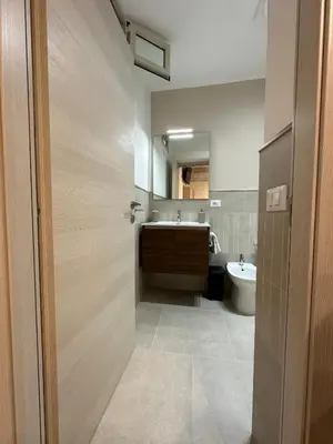 a bathroom with a sink and a toilet and a mirror at A Little Modern House in Palermo