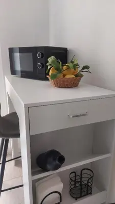a bowl of fruit on a table with a microwave at L'ulivo-casa tua a Palermo, a due passi dal centro in Palermo