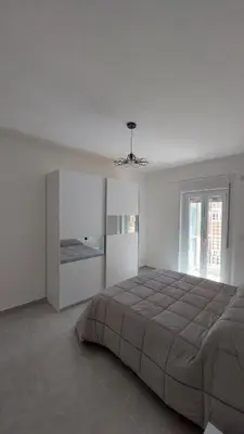 a white bedroom with a large bed and a window at L'ulivo-casa tua a Palermo, a due passi dal centro in Palermo