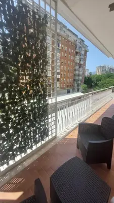 a balcony with two chairs and a large window at L'ulivo-casa tua a Palermo, a due passi dal centro in Palermo