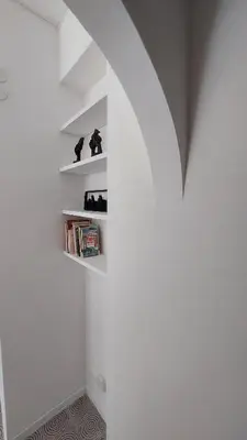 a room with a white wall with shelves at L'ulivo-casa tua a Palermo, a due passi dal centro in Palermo