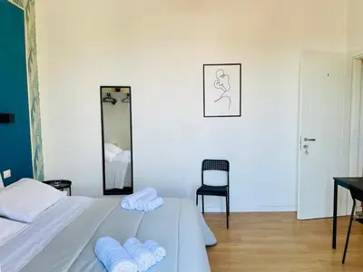 a bedroom with a bed and a desk and a mirror at La casa di Didì in Palermo