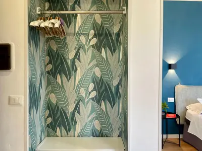 a glass shower door with a green leafy wall at La casa di Didì in Palermo