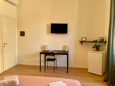 a room with a desk with a television on a wall at La casa di Didì in Palermo