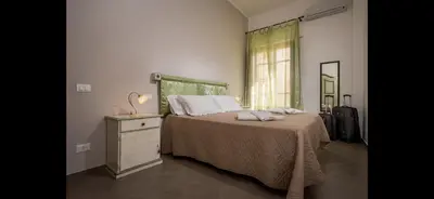 a bedroom with a bed and a dresser and a window at Borgo la Madrice in Castellammare del Golfo