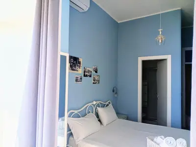 a bedroom with a bed with a blue wall at Case Nereidi 3 in Porticello