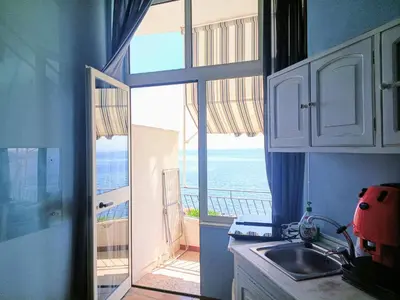 a kitchen with a view of the ocean from a balcony at Case Nereidi 3 in Porticello