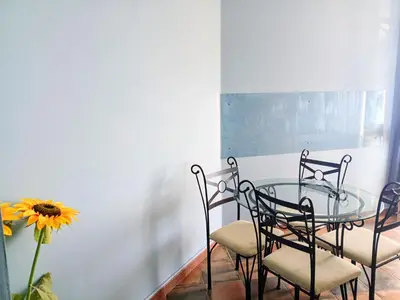 a glass table with chairs and a vase with a sunflower at Case Nereidi 3 in Porticello