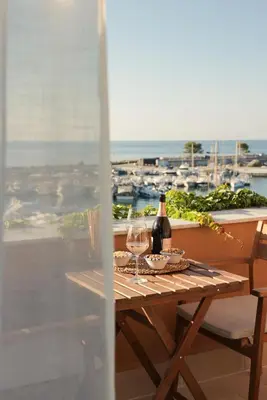 a table with a bottle of wine and two glasses at Almarìa - Le case del Castello - San Nicola L'Arena - Trabia in Trabia